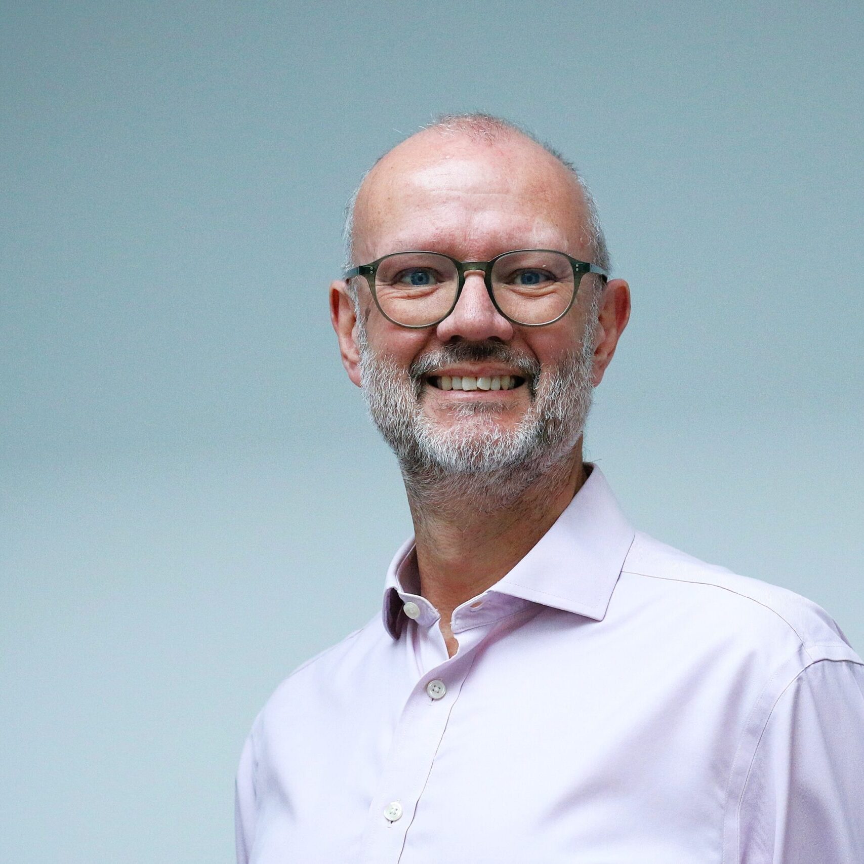 photo of the Independent mortgage Broker Alex Cooke smiling and wearing a pink shirt and no tie.