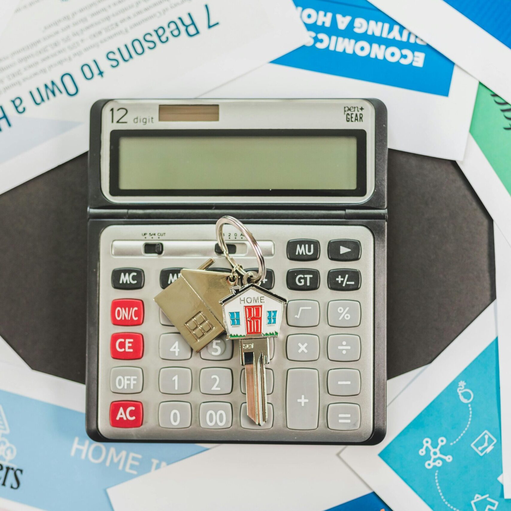 Calculator and House Keys Surrounded by Mortgage Paperwork